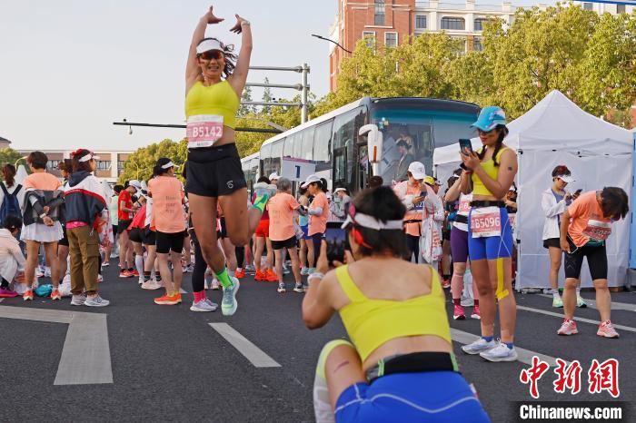 清晨初升的朝阳映照城市，上海女子半马鸣枪开
